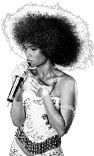 Person with large afro hairstyle wearing a sequined outfit is singing into a microphone on stage. Description generated by AI